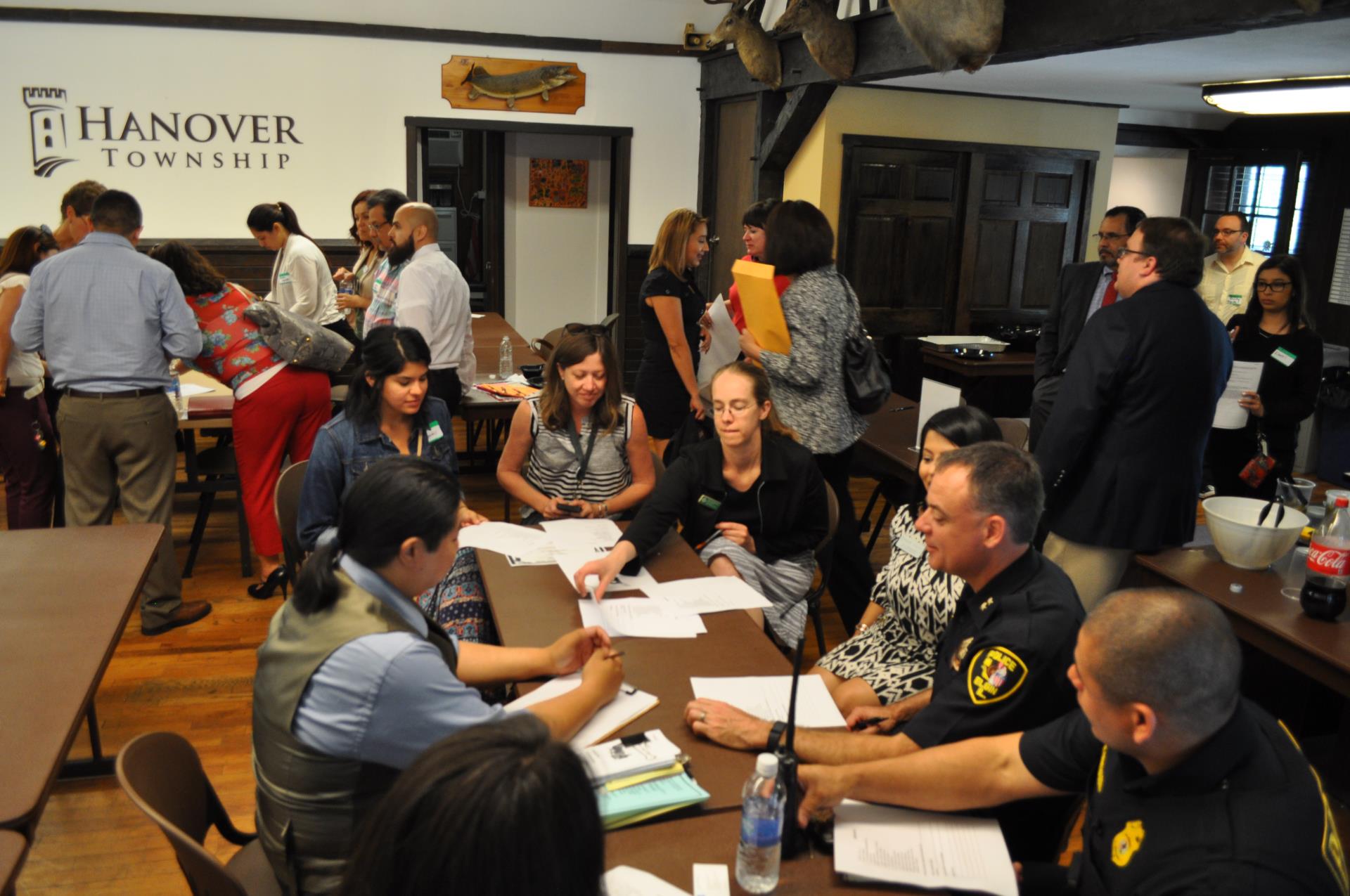 Group of men and women are sitting at a table reviewing papers that are on the table.