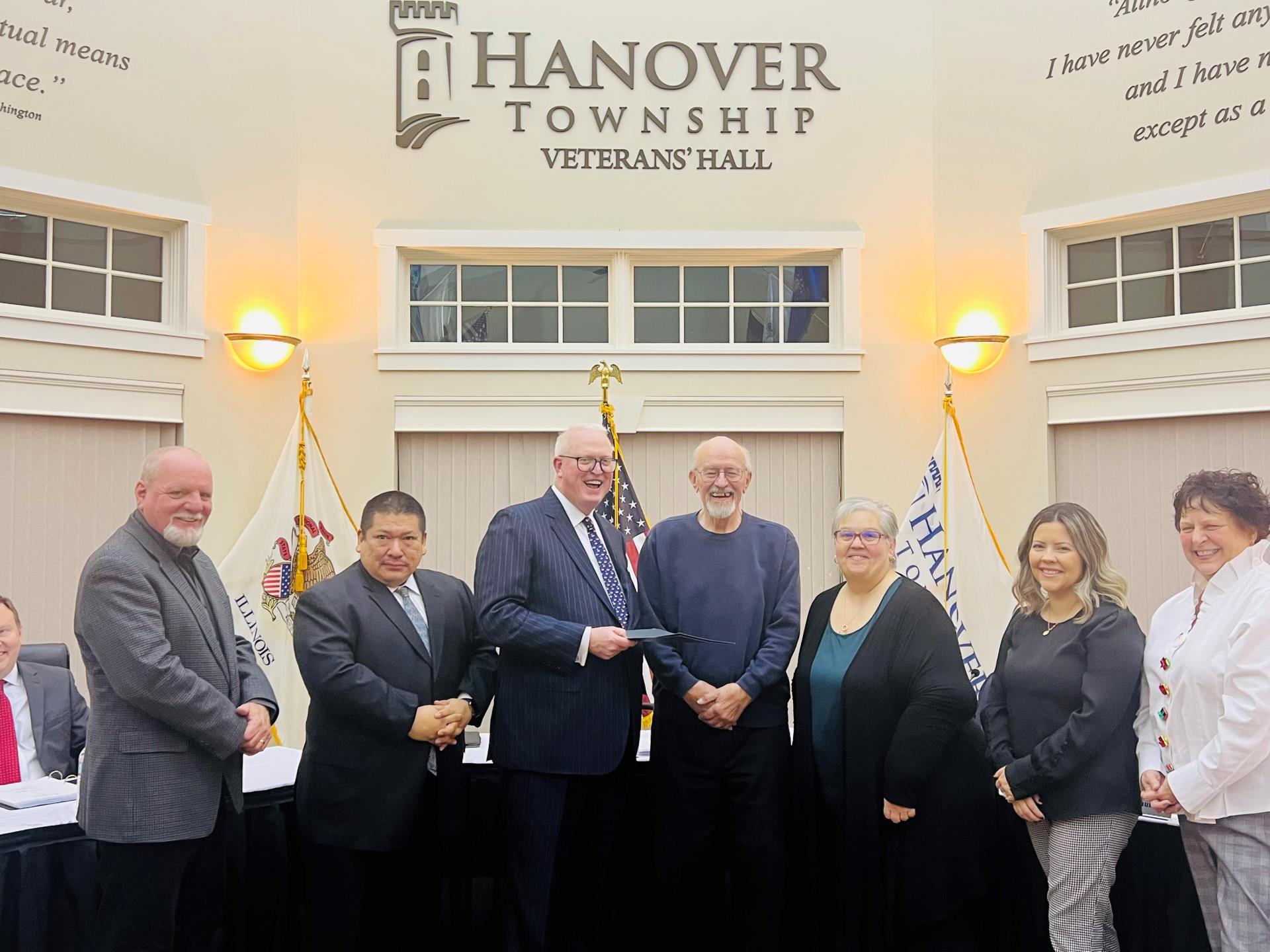 Hanover Township officials standing with a Veteran facing the camera while he holds his honor roll i…