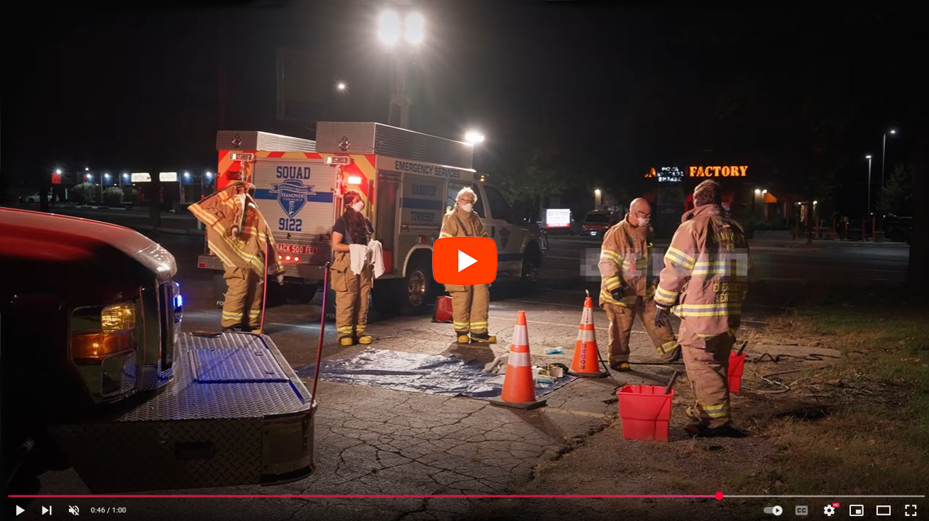 Emergency services volunteers setting up a scene at night in front of a lighting vehicle