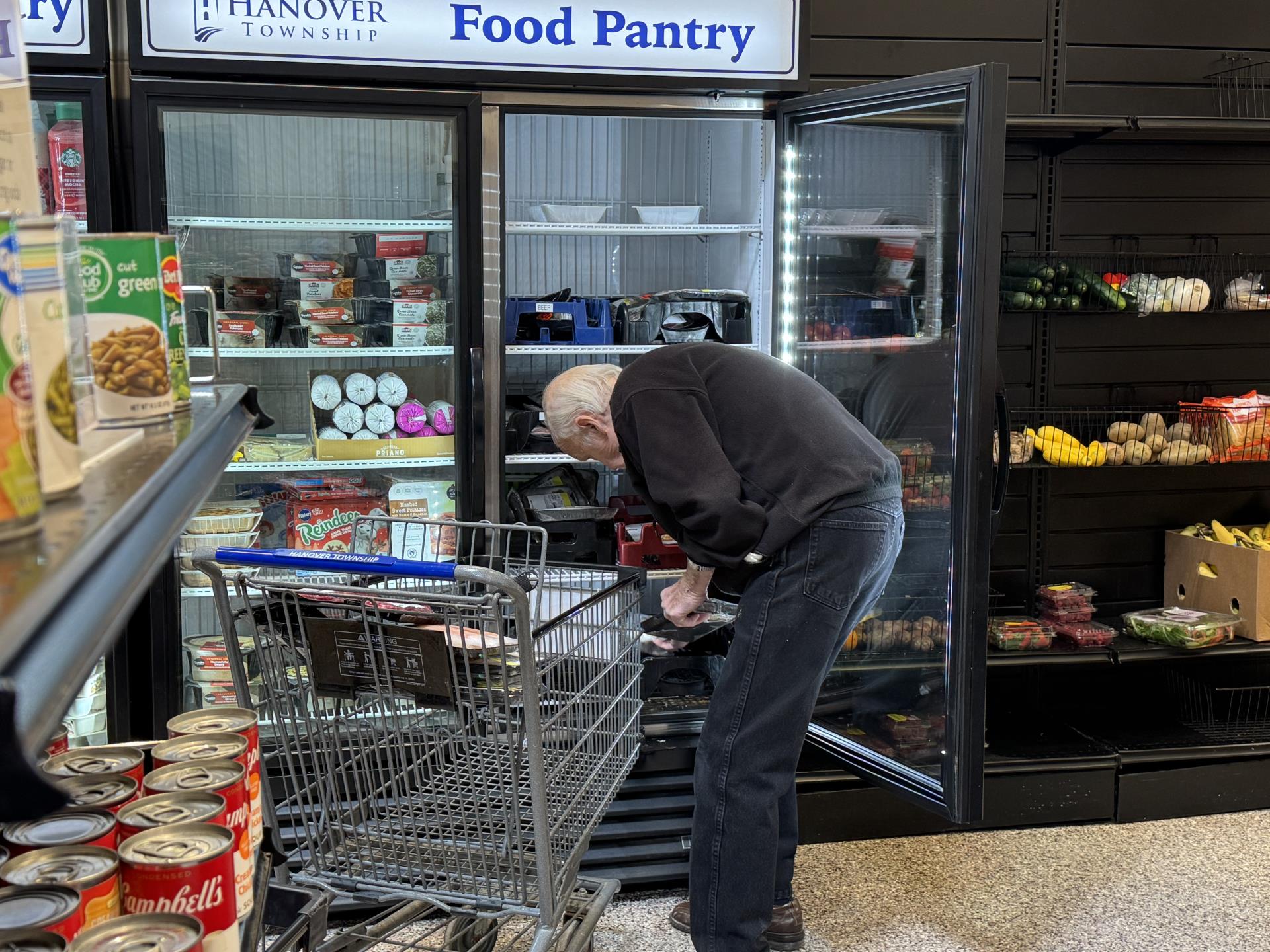 older man reaching into a fridge at the Hanover Township Food Pantry